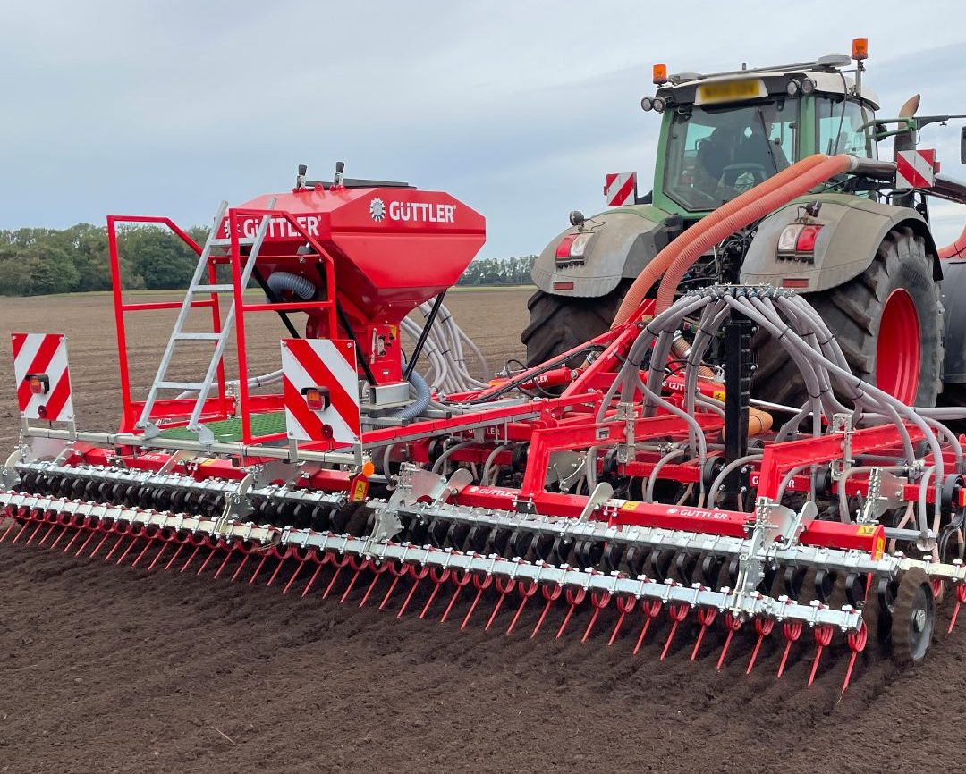 Semoir rouge Guttler avec herse arrière pour une implantation précise et sécurisée de vos cultures.