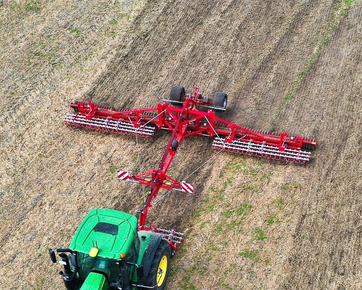 Vue aérienne d'un rouleau lourd Guttler cassant les mottes pour bloquer l'évaporation et protéger les semis.