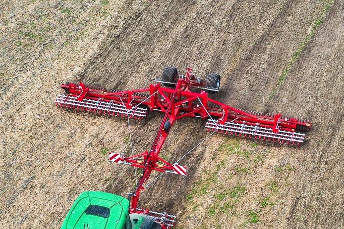 Vue aérienne d'un rouleau Guttler rouge au travail pour casser les mottes et réamorcer la capillarité de l'eau.