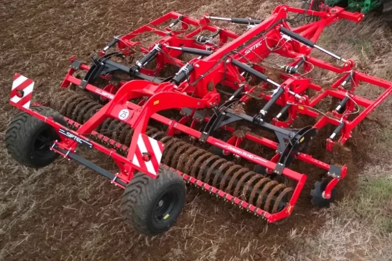 Déchaumeur à dents rouge Siptec stationné, montrant sa structure robuste et son rouleau arrière.