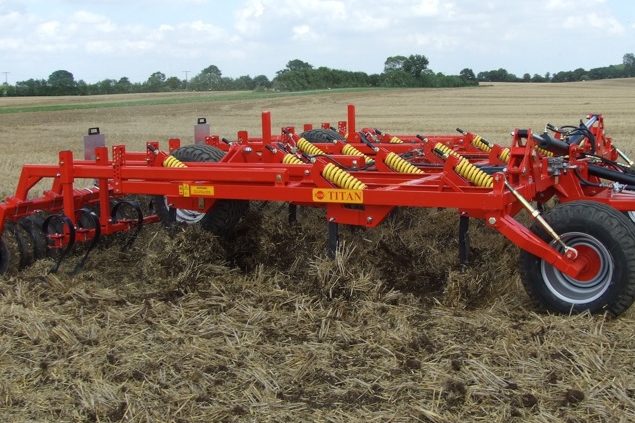 Grand déchaumeur à dents rouge Brix en train de travailler dans des chaumes.