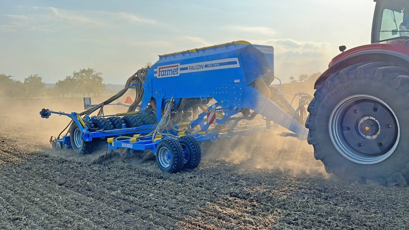 Machines agricoles bleues Farmet attelées à des tracteurs, illustrant la polyvalence de la marque pour l'implantation des cultures.