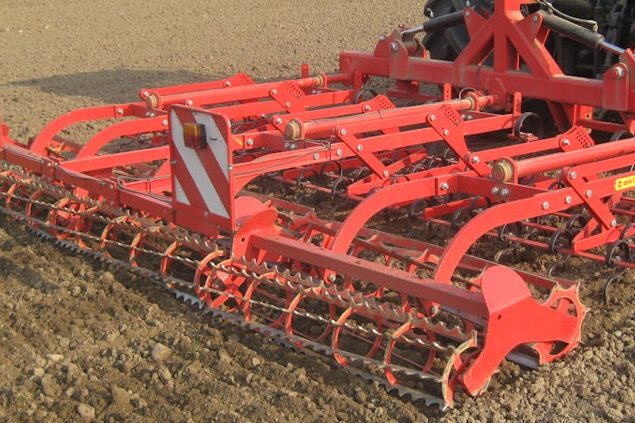 Préparateur de lit de semence rouge Brix en action pour garantir un contact direct de la graine avec le sol.