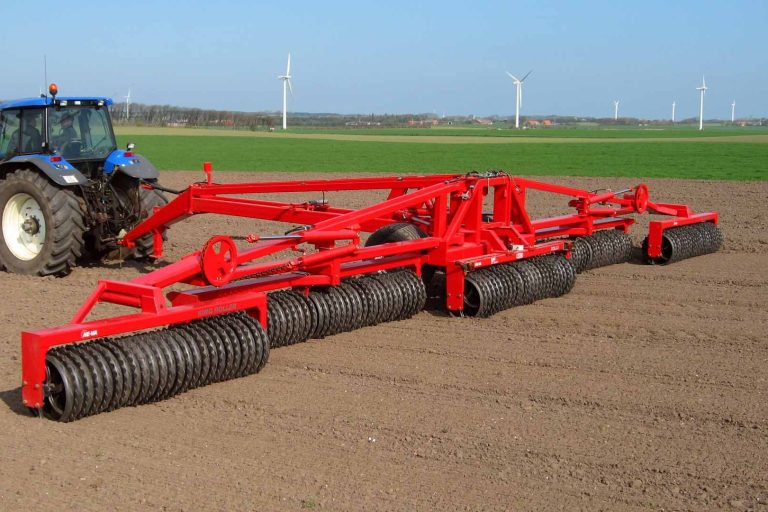 Tracteur tirant un grand rouleau agricole rouge He-Va pour un rappuyage lourd et garantir des levées homogènes.
