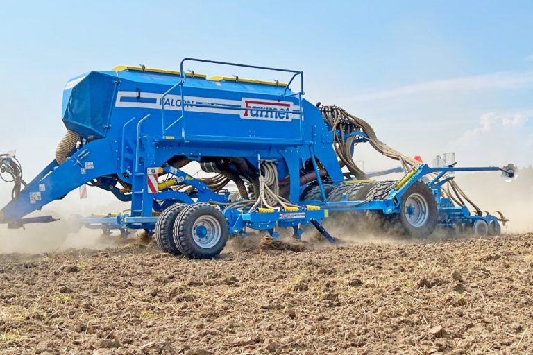 Semoir bleu Farmet au travail dans un champ pour garantir un contact terre-graine optimal lors de l'implantation.