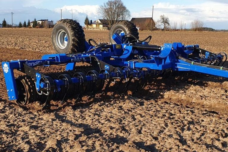 Rouleau agricole bleu Landstal replié sur un sol motteux, conçu pour un rappuyage ciblé et efficace.